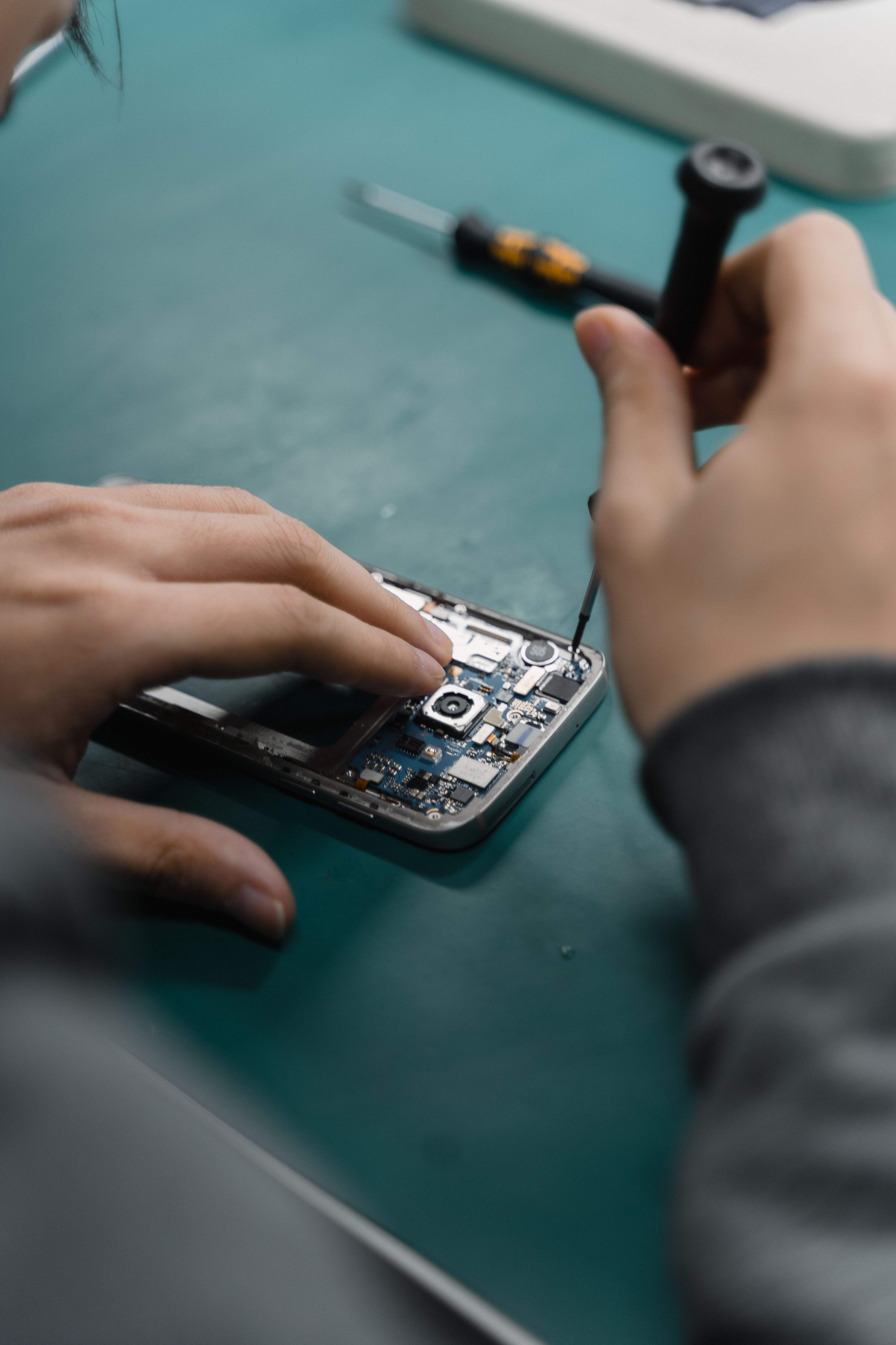 Techniker repariert ein Smartphone in der City Phone Werkstatt Bochum