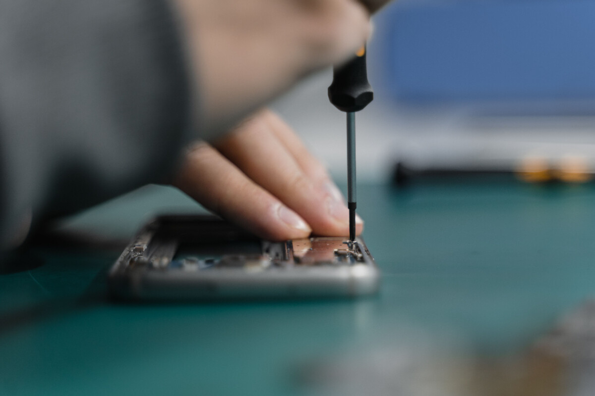Techniker öffnet ein Smartphone zur Reparatur in der City Phone Werkstatt Bochum
